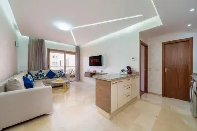 a large living room with a couch and a kitchen at Red appart in Marrakech