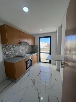 a kitchen with marble flooring and a large window at Le Paradis Balnéaire - 2 min Plage - 2 chambres in Marrakech
