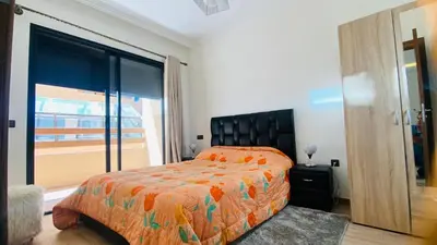 a bedroom with a bed and a large window at Résidence nour 5 in Marrakech