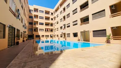 an apartment building with a swimming pool in a courtyard at Résidence nour 5 in Marrakech
