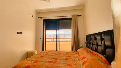 a bedroom with a bed and a large window at Résidence nour 5 in Marrakech