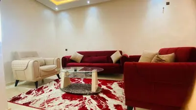a living room with two red couches and a table at Résidence nour 5 in Marrakech