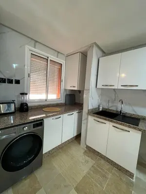 a small kitchen with white cabinets and a dishwasher at Appartement 3 chambres Gueliz Hivernage Marrakech centre 5 Etage M21 in Marrakech