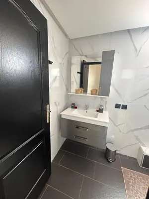 a white bathroom with a sink and a mirror at Appartement 3 chambres Gueliz Hivernage Marrakech centre 5 Etage M21 in Marrakech