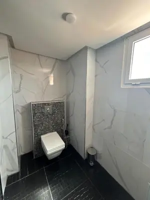 a white bathroom with a toilet and a window at Appartement 3 chambres Gueliz Hivernage Marrakech centre 5 Etage M21 in Marrakech