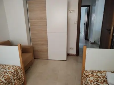 a room with two beds and a door to a hallway at Appartement Familial à Marrakech avec des espaces verts et 5 piscines in Marrakech