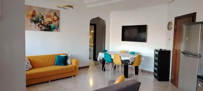 a living room with a couch and a table and chairs at Appartement Familial à Marrakech avec des espaces verts et 5 piscines in Marrakech