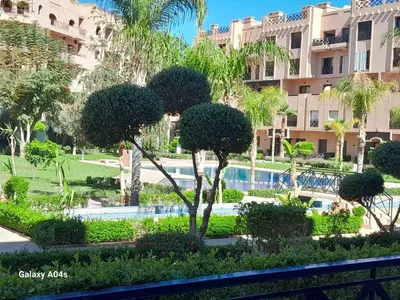 a view of a resort with a swimming pool and trees at Appartement Familial à Marrakech avec des espaces verts et 5 piscines in Marrakech