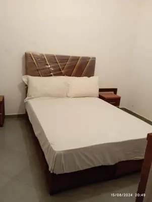 a bed with a wooden headboard in a room at Appartement Chic à Marrakech in Marrakech