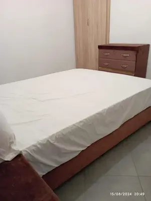a bedroom with a bed and a wooden dresser at Appartement Chic à Marrakech in Marrakech