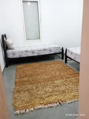 a living room with a brown rug and a couch at Appartement Chic à Marrakech in Marrakech
