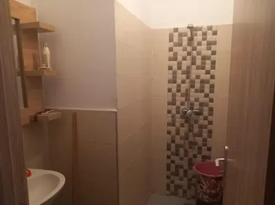 a small bathroom with a shower and a sink at Appartement Chic à Marrakech in Marrakech