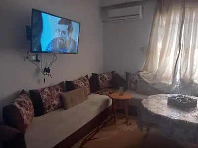 a living room with a couch and a tv on the wall at Appartement Chic à Marrakech in Marrakech