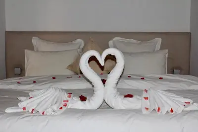 two white swans making a heart on a bed at La Maison Berber Shams in Marrakech