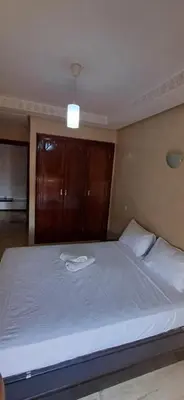 a bedroom with a large bed with a white blanket at Résidence hamza appartement 2 chambre in Marrakech