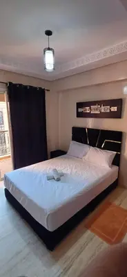 a bedroom with a large bed with white sheets at Résidence hamza appartement 2 chambre in Marrakech