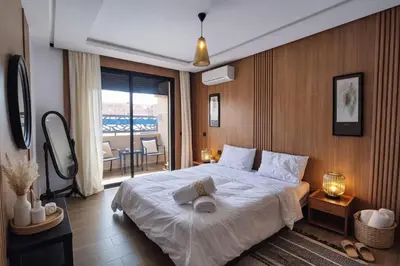 a bedroom with a large bed and a balcony at Luxury Apartment in Hivernage Marrakech in Marrakech