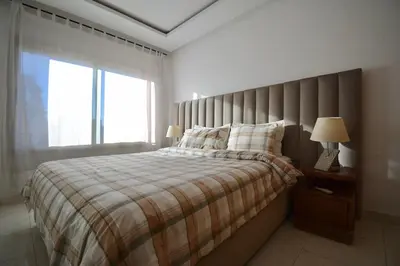 a bedroom with a large bed and a window at Appart charmante au cour de marrakech l'hivernage in Marrakech