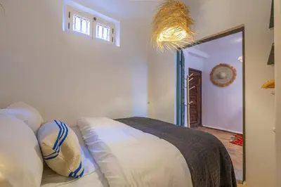 a bedroom with a couch and a large mirror at Riad YANNIS in Marrakech