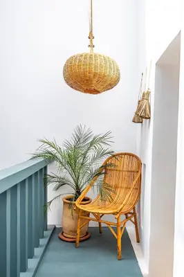a rattan chair sitting next to a potted plant at Riad YANNIS in Marrakech