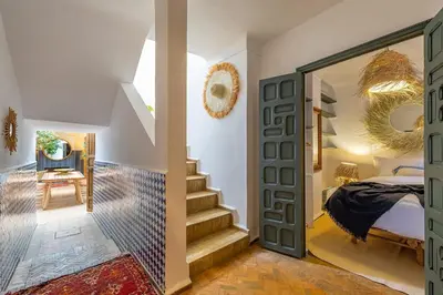 a bedroom with a bed and a door with a mirror at Riad YANNIS in Marrakech