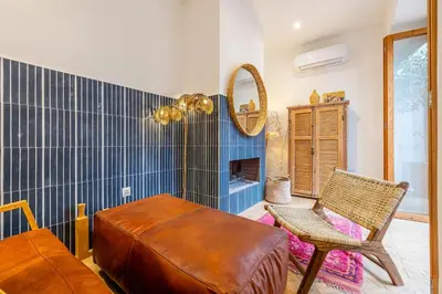 a room with a bench and a chair and a mirror at Riad YANNIS in Marrakech