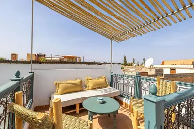 a patio with a couch and chairs on a balcony at Riad YANNIS in Marrakech
