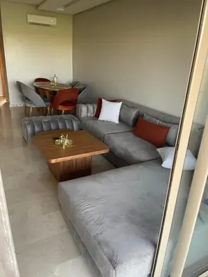 a living room with a couch and a table at Appartement luxueux à Prestigia SAPHIR in Marrakech