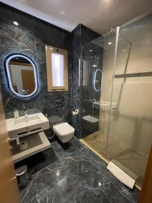 a bathroom with a shower and a toilet and a sink at Appartement luxueux à Prestigia SAPHIR in Marrakech