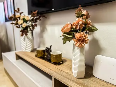 two vases with flowers on a table with two cups at L'Havre de Paix - Proxi Centre - 2 Chambres in Marrakech