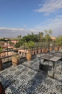a balcony with a table and potted plants on it at medina View Apartment in Marrakech