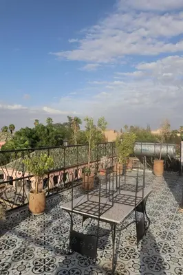 a patio with tables and potted plants on a balcony at medina View Apartment in Marrakech