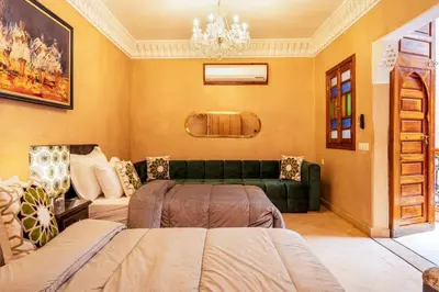 a living room with a green sofa and a couch at Charmant Riad privatif au cœur de la Médina in Marrakech