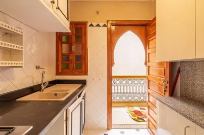 a kitchen with a sink and an open door at Charmant Riad privatif au cœur de la Médina in Marrakech