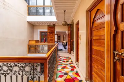 a hallway with a balcony with a rug at Charmant Riad privatif au cœur de la Médina in Marrakech