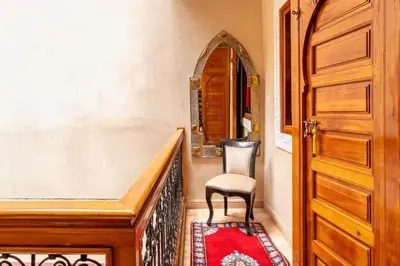 a hallway with a chair and a wooden door at Charmant Riad privatif au cœur de la Médina in Marrakech