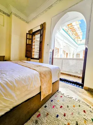 a bedroom with a bed and a large window at Riad Vilamoura & SPA in Marrakech