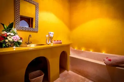 a bathroom with a sink and a tub and a mirror at Riad Vilamoura & SPA in Marrakech