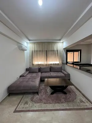 a living room with a large couch and a table at Appartement 2 chambres Luxueuse centre Guéliz opr 15 in Marrakech