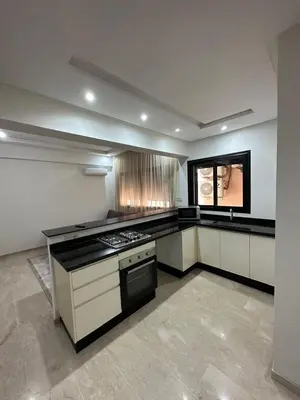a kitchen with white cabinets and a stove top oven at Appartement 2 chambres Luxueuse centre Guéliz opr 15 in Marrakech
