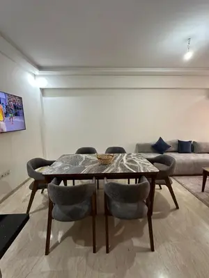 a table and chairs in a living room with a couch at Appartement 2 chambres Luxueuse centre Guéliz opr 15 in Marrakech