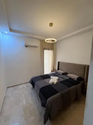 a bedroom with a large bed with a blue blanket at Appartement 2 chambres Luxueuse centre Guéliz opr 15 in Marrakech