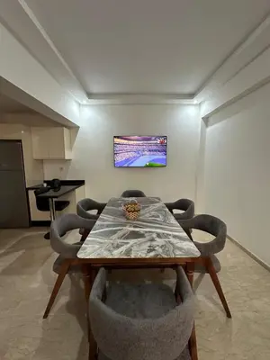 a dining room with a wooden table and chairs at Appartement 2 chambres Luxueuse centre Guéliz opr 15 in Marrakech