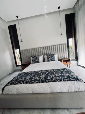 a bedroom with a large bed and two windows at Dream villa in Marrakech