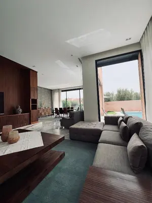 a living room with a large couch and a large window at Dream villa in Marrakech