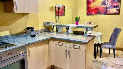 a kitchen with a counter and a table and chairs at Palmeraie vue piscine 3 in Marrakech