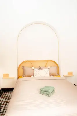 a bed with an arch headboard in a bedroom at Riad Tamazigh in Marrakech
