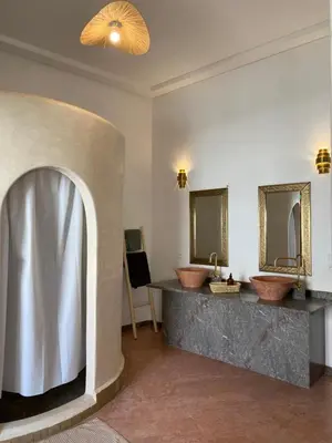 a bathroom with two sinks and two mirrors at Riad Tamazigh in Marrakech