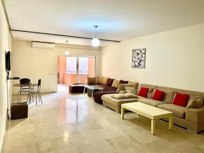 a living room with a couch and a table at Apparemment 1 chambre salon à coté de la gare guéliz 20 in Marrakech