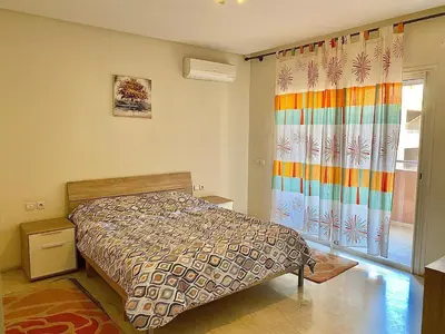 a bedroom with a bed and a colorful shower curtain at Apparemment 1 chambre salon à coté de la gare guéliz 20 in Marrakech